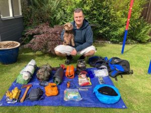 This image shows Dave with his dog, and his wild camping kit layed out in the garden.